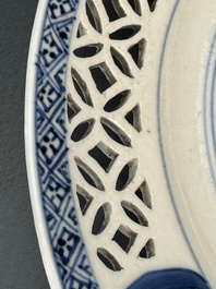 A pair of Chinese blue and white plates with floral design and reticulated border, conical shell mark, Kangxi