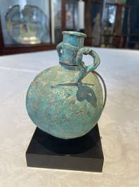 A bronze urn, a bronze canteen with relief design and a pair of bronze oil lamps, Roman Empire, 9th C. B.C/5th C.