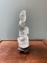 A Chinese rock crystal sculpture of Lan Caihe on wooden stand, 19th C.