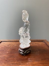 A Chinese rock crystal sculpture of Lan Caihe on wooden stand, 19th C.
