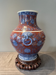 A Chinese blue, white and iron-red 'bajixiang' 'hu' vase on wooden stand, Qianlong mark, 19th C.