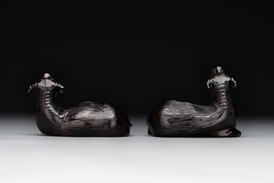 A pair of Chinese cherry amber or faturan recumbent oxen on wooden stands, Republic