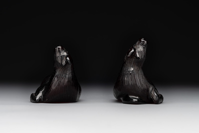 A pair of Chinese cherry amber or faturan recumbent oxen on wooden stands, Republic