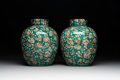A pair of Chinese famille verte green-ground 'prunus' jars and covers, 19th C.