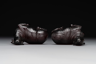 A pair of Chinese cherry amber or faturan recumbent oxen on wooden stands, Republic