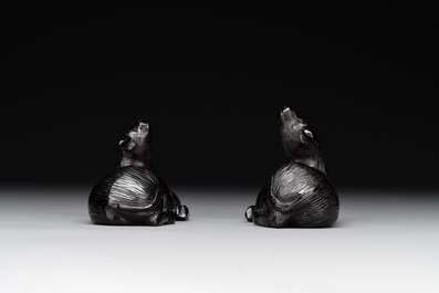 A pair of Chinese cherry amber or faturan recumbent oxen on wooden stands, Republic