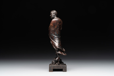 A fine Chinese bronze Luohan holding a sutra, Ming
