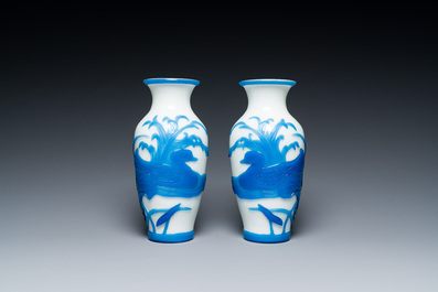 A pair of Chinese blue-overlay white Beijing glass vases with mandarin ducks and a orange-overlay white bottle vase, 19/20th C.