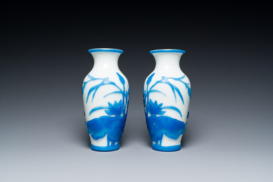 A pair of Chinese blue-overlay white Beijing glass vases with mandarin ducks and a orange-overlay white bottle vase, 19/20th C.