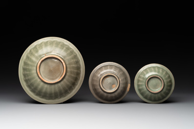 A Chinese Longquan celadon 'twin fish' dish and two 'twin fish' saucers, Yuan/Ming