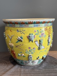 A Chinese famille rose yellow-ground relief-molded 'antiquities' fish bowl, Zhengde mark, 19th C.