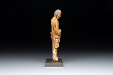 A Chinese gilt and polychromed stucco figure of a monk, Ming