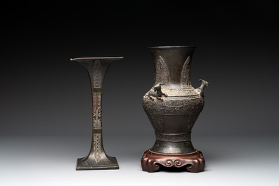 A Chinese archaistic bronze 'gu' vase and a 'hu' vase with rams in relief on a wooden stand, 18/19th C.
