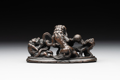 A rare Chinese bronze 'three dancing lions' paperweight or brush rest, Ming