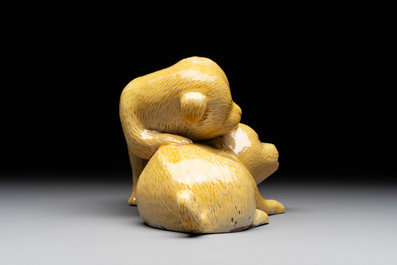 A Japanese monochrome yellow-glazed 'two playing dogs' group, 19th C.