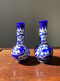 A pair of Chinese blue-overlay white Beijing glass 'chilong' bottle vases, 19th C.