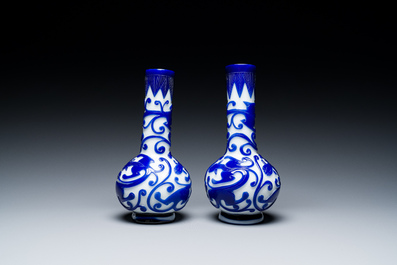 A pair of Chinese blue-overlay white Beijing glass 'chilong' bottle vases, 19th C.