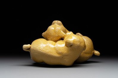 A Japanese monochrome yellow-glazed 'two playing dogs' group, 19th C.