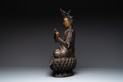 An impressive and large Chinese partially lacquered and gilt bronze Guanyin on a lotus throne, Ming