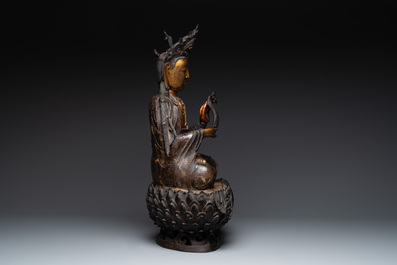 An impressive and large Chinese partially lacquered and gilt bronze Guanyin on a lotus throne, Ming
