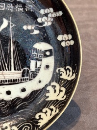A Chinese iron-red 'bat' saucer and a black-glazed 'ship' saucer with calligraphy, Guangxu mark, 19th C.