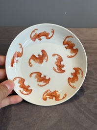 A Chinese iron-red 'bat' saucer and a black-glazed 'ship' saucer with calligraphy, Guangxu mark, 19th C.