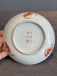 A Chinese iron-red 'bat' saucer and a black-glazed 'ship' saucer with calligraphy, Guangxu mark, 19th C.