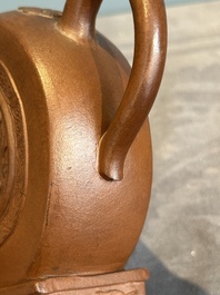 A Chinese circle-shaped Yixing stoneware 'kylin' teapot with relief design, Kangxi