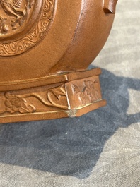 A Chinese circle-shaped Yixing stoneware 'kylin' teapot with relief design, Kangxi