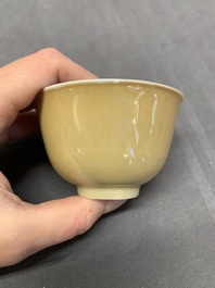 Five Chinese caf&eacute;-au-lait-ground blue and white cups and four saucers, conical shell mark, Kangxi