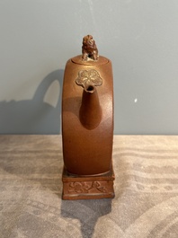 A Chinese circle-shaped Yixing stoneware 'kylin' teapot with relief design, Kangxi