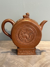 A Chinese circle-shaped Yixing stoneware 'kylin' teapot with relief design, Kangxi
