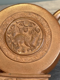 A Chinese circle-shaped Yixing stoneware 'kylin' teapot with relief design, Kangxi