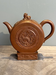 A Chinese circle-shaped Yixing stoneware 'kylin' teapot with relief design, Kangxi