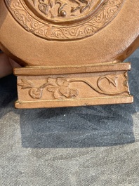 A Chinese circle-shaped Yixing stoneware 'kylin' teapot with relief design, Kangxi