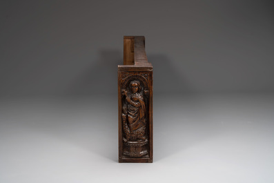 A carved front panel of a Gothic walnut chest with female saints, alcoves and rosettes, France, early 16th C.