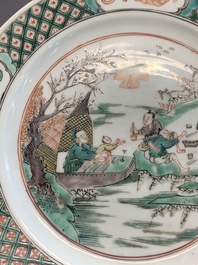 A pair of Chinese famille verte plates with figures along the riverside, artemisia leaf and ding mark, Kangxi