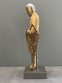 A Chinese gilt and polychromed stucco figure of a monk, Ming