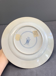 A pair of Chinese famille verte plates with figures along the riverside, artemisia leaf and ding mark, Kangxi