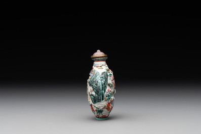 A Chinese famille rose relief-molded snuff bottle with an animated river landscape, Jiaqing mark and of the period