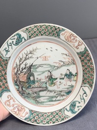A pair of Chinese famille verte plates with figures along the riverside, artemisia leaf and ding mark, Kangxi