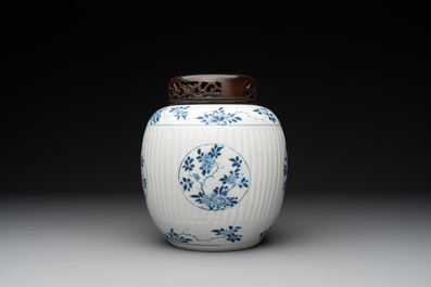 A Chinese blue and white jar with floral design and a wooden cover, Kangxi