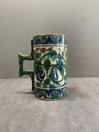 A polychrome Iznik-style mug with tulips and carnations, Kutahya, Turkey, 19th C.