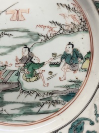 A pair of Chinese famille verte plates with figures along the riverside, artemisia leaf and ding mark, Kangxi