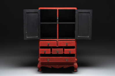 A Chinese cinnabar lacquer 'mountainous landscape' cabinet on a stand, 19th C.