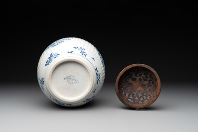 A Chinese blue and white jar with floral design and a wooden cover, Kangxi