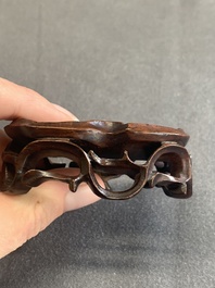 A pair of Chinese cherry amber or faturan recumbent oxen on wooden stands, Republic