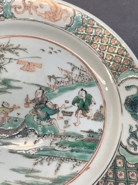 A pair of Chinese famille verte plates with figures along the riverside, artemisia leaf and ding mark, Kangxi