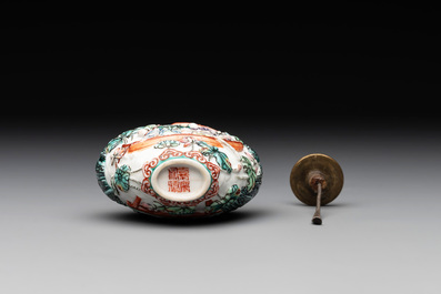 A Chinese famille rose relief-molded snuff bottle with an animated river landscape, Jiaqing mark and of the period