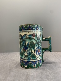 A polychrome Iznik-style mug with tulips and carnations, Kutahya, Turkey, 19th C.